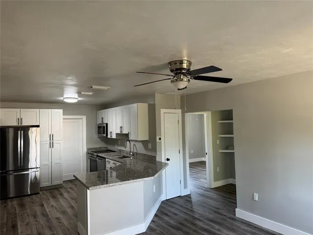 a kitchen with stainless steel appliances a refrigerator and wooden floor