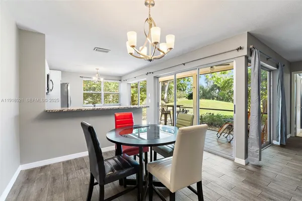 a view of a dining room with furniture a chandelier and wooden floor