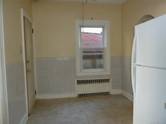 a view of a kitchen with cabinet and washer dryer