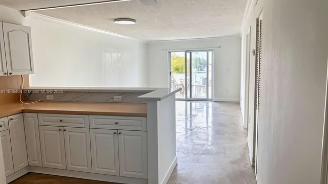 a view of a kitchen with white cabinets and a sink