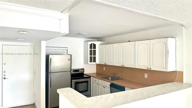 a kitchen with a refrigerator sink and cabinets