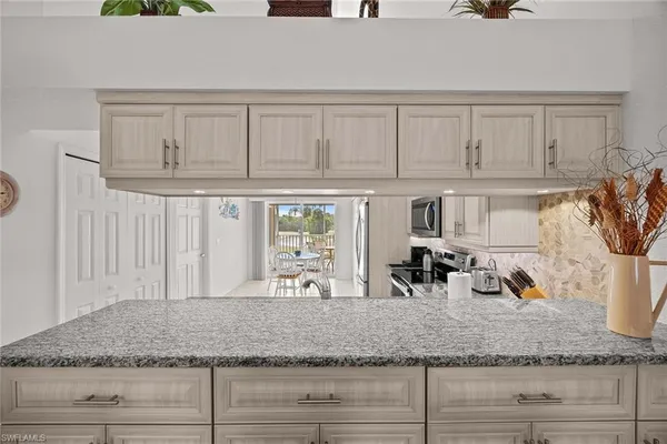a kitchen with granite countertop a sink a stove and cabinets