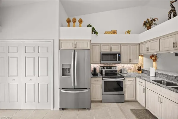 a kitchen with white cabinets and stainless steel appliances