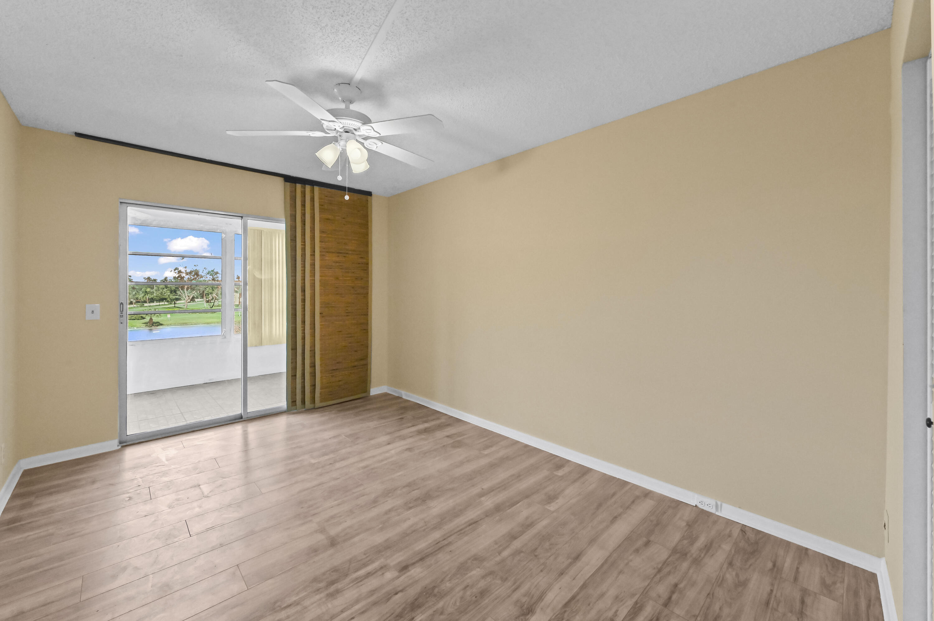 3046 Newcastle A Boca Raton, FL 33434 - Photo 13 of 25 a view of a livingroom with wooden floor and a ceiling fan