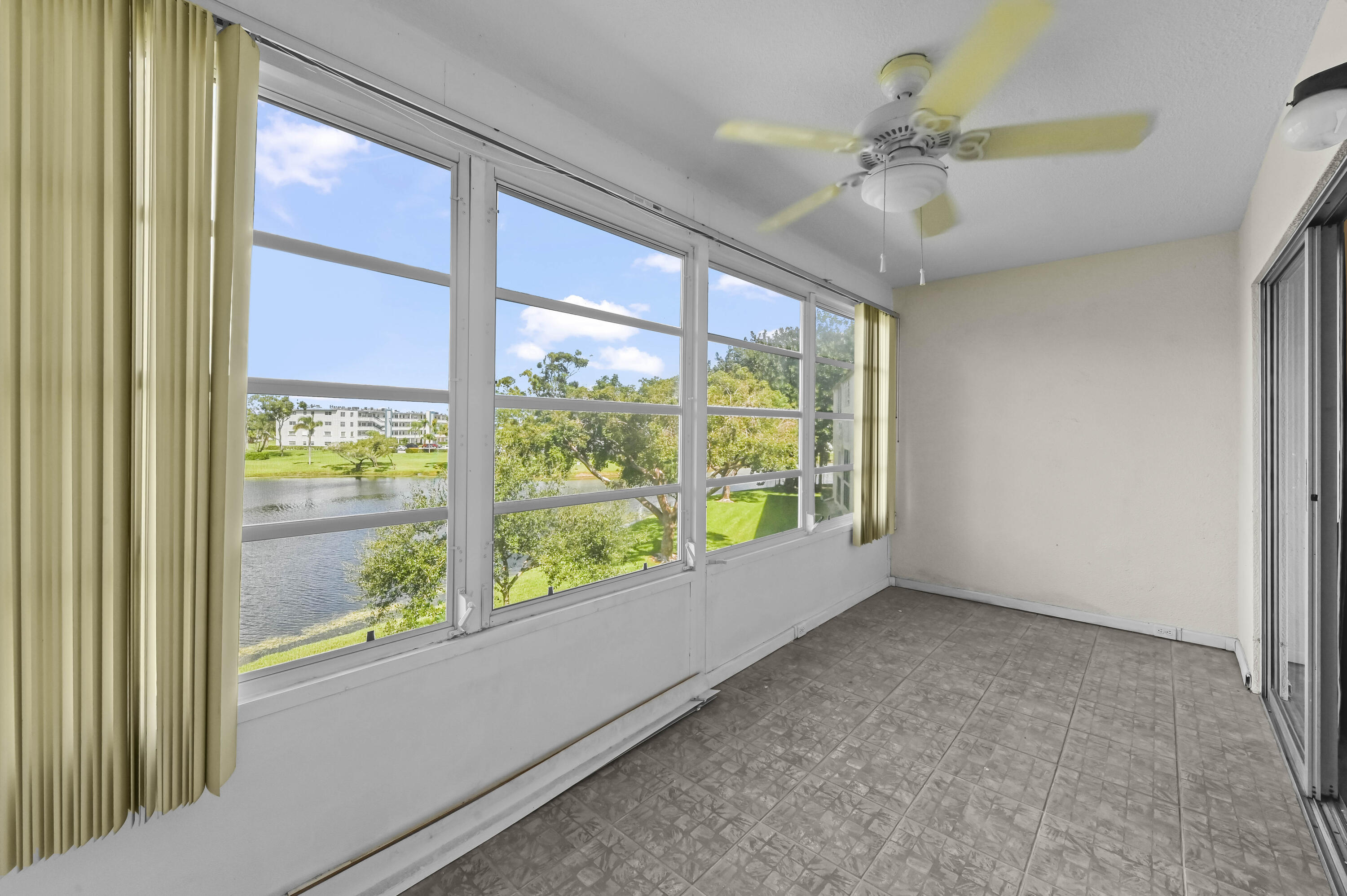 3046 Newcastle A Boca Raton, FL 33434 - Photo 22 of 25 a view of room with window and a ceiling fan