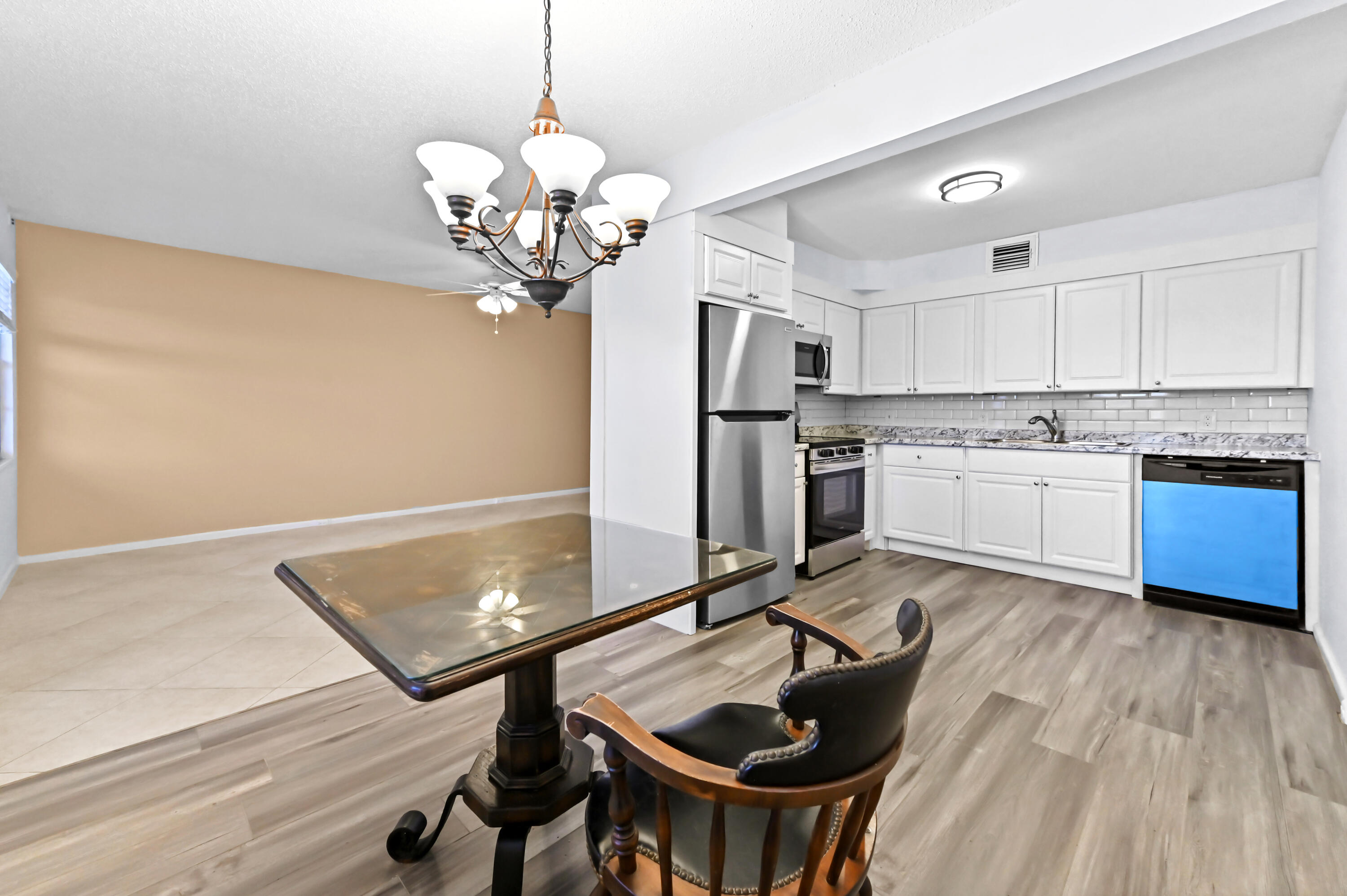 3046 Newcastle A Boca Raton, FL 33434 - Photo 9 of 25 a kitchen with kitchen island a dining table chairs stainless steel appliances and cabinets