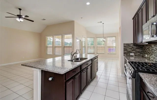 a kitchen with granite countertop a sink a counter top space and cabinets