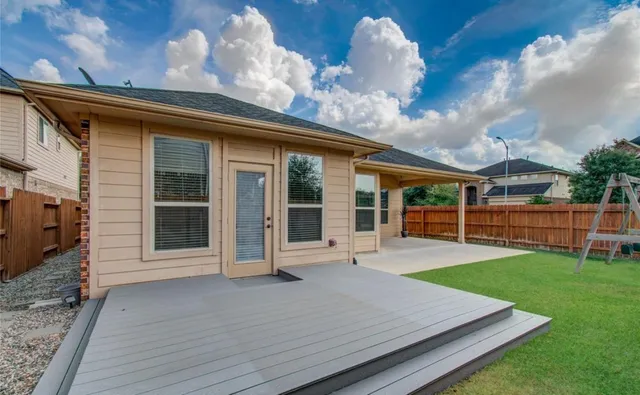a view of a backyard with table and chairs and wooden fence