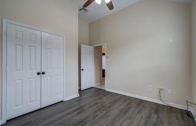 a view of an empty room and wooden floor chandelier fan
