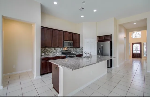 a kitchen with stainless steel appliances granite countertop a refrigerator and a sink