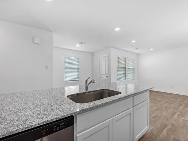 a kitchen with granite countertop white cabinets and sink
