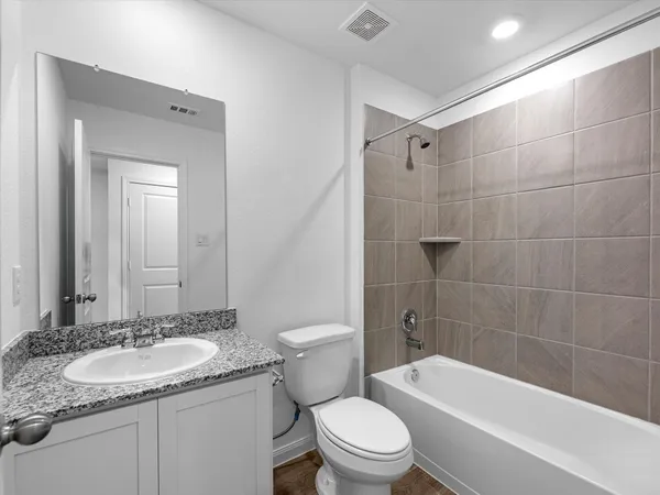 a bathroom with a granite countertop sink toilet and shower