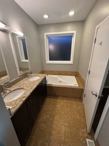 a bathroom with a granite countertop sink mirror vanity and toilet