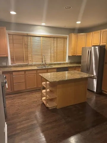 a kitchen with stainless steel appliances granite countertop a sink and a stove