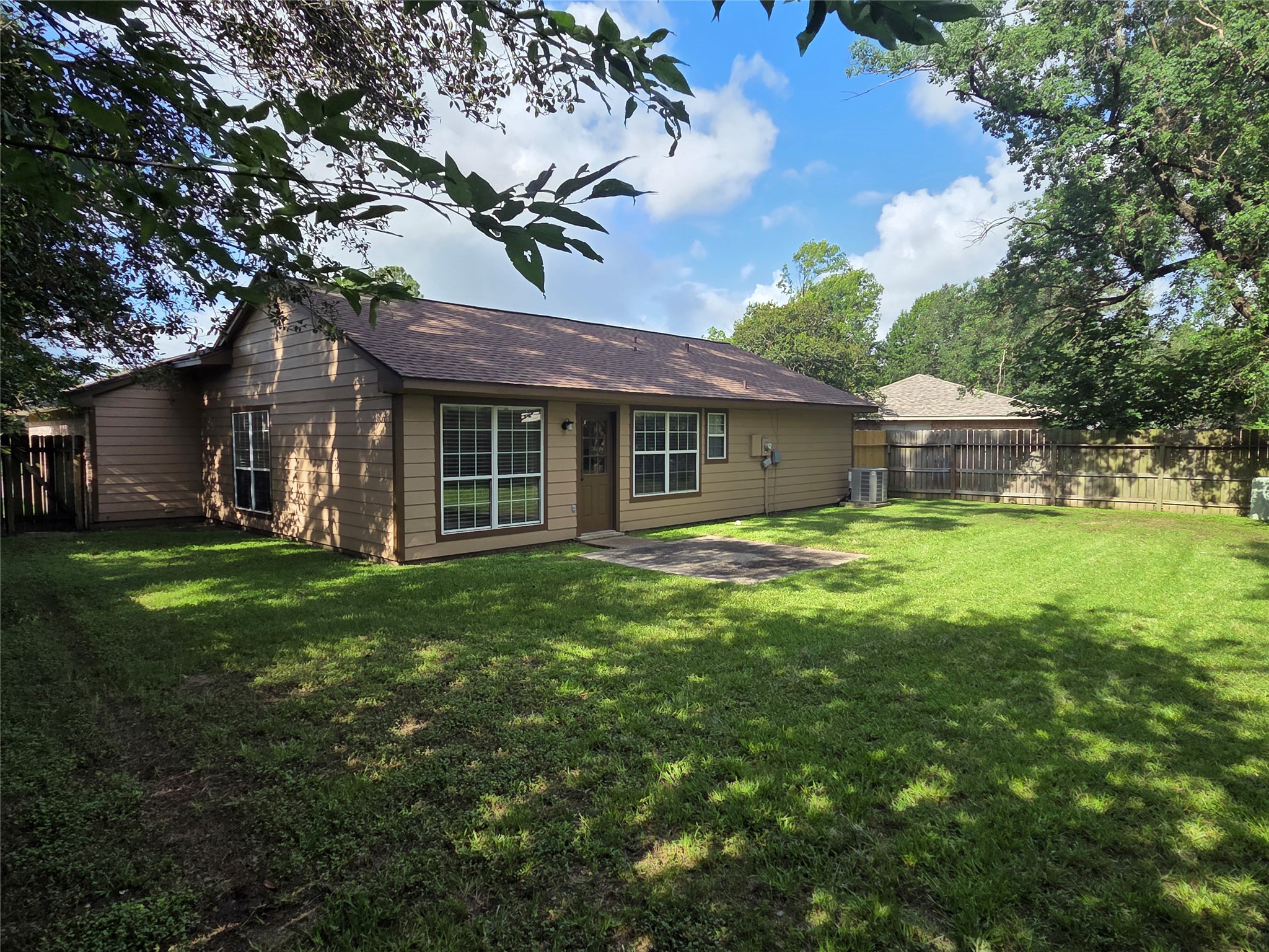 4203 Spinks Creek Lane Spring, TX 77388 - Photo 3 of 3 This home features a spacious, shaded yard framed by mature trees and a sturdy privacy fence, offering both comfort and seclusion.