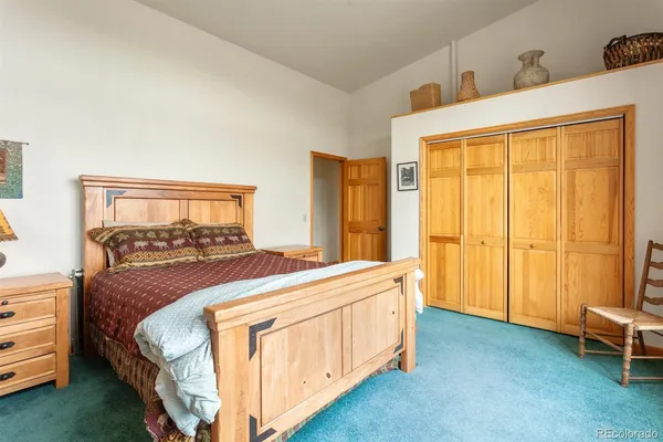 a bedroom with two beds and next to a window