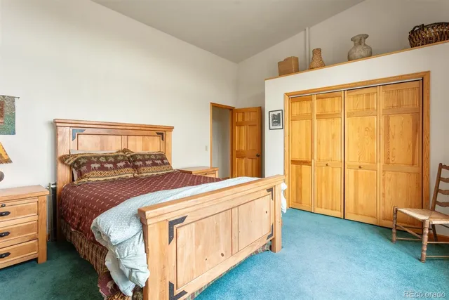 a bedroom with two beds and next to a window