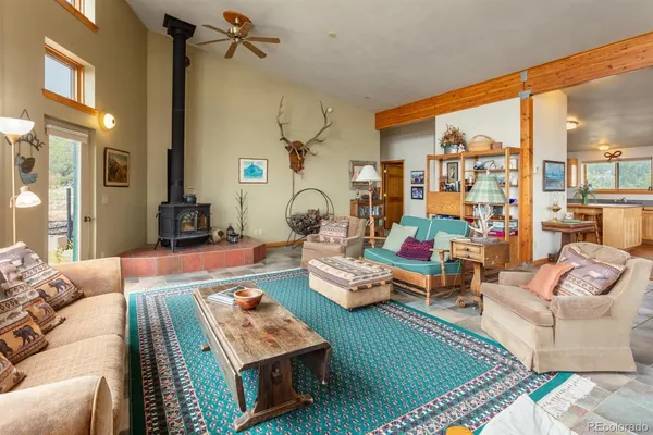 a living room with furniture kitchen view and a large window