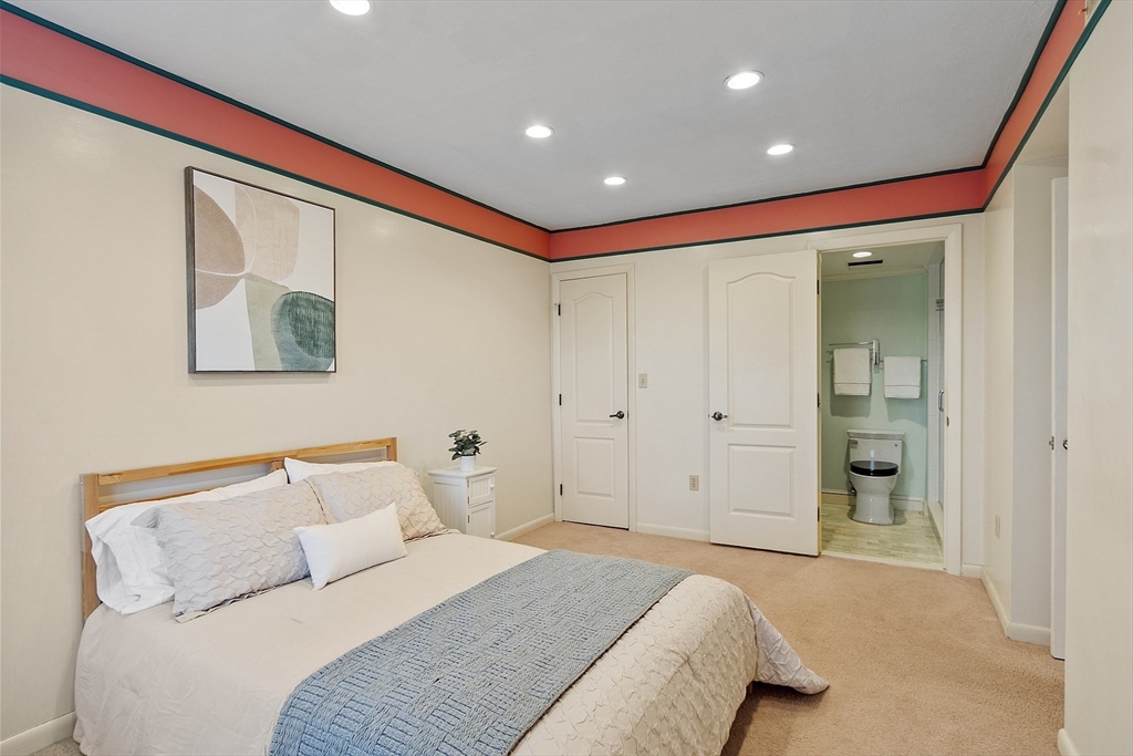 200 Falls Boulevard, Unit D108 Quincy, MA 02169 - Photo 11 of 30 a spacious bedroom with a bed and a painting
