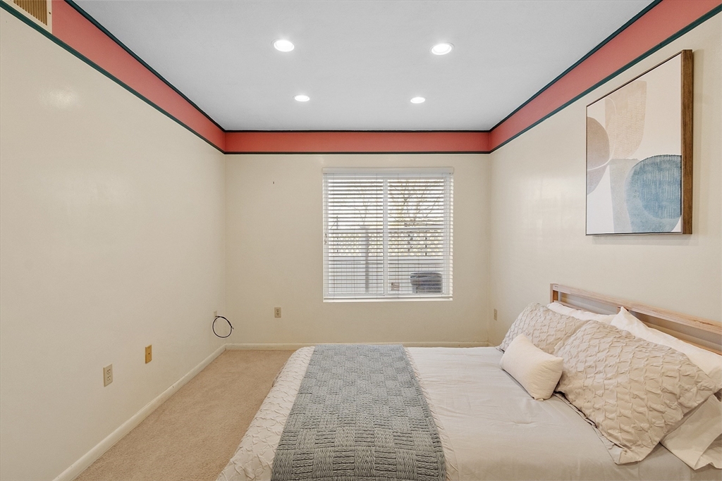 200 Falls Boulevard, Unit D108 Quincy, MA 02169 - Photo 14 of 30 a bedroom with a bed and a painting on the wall