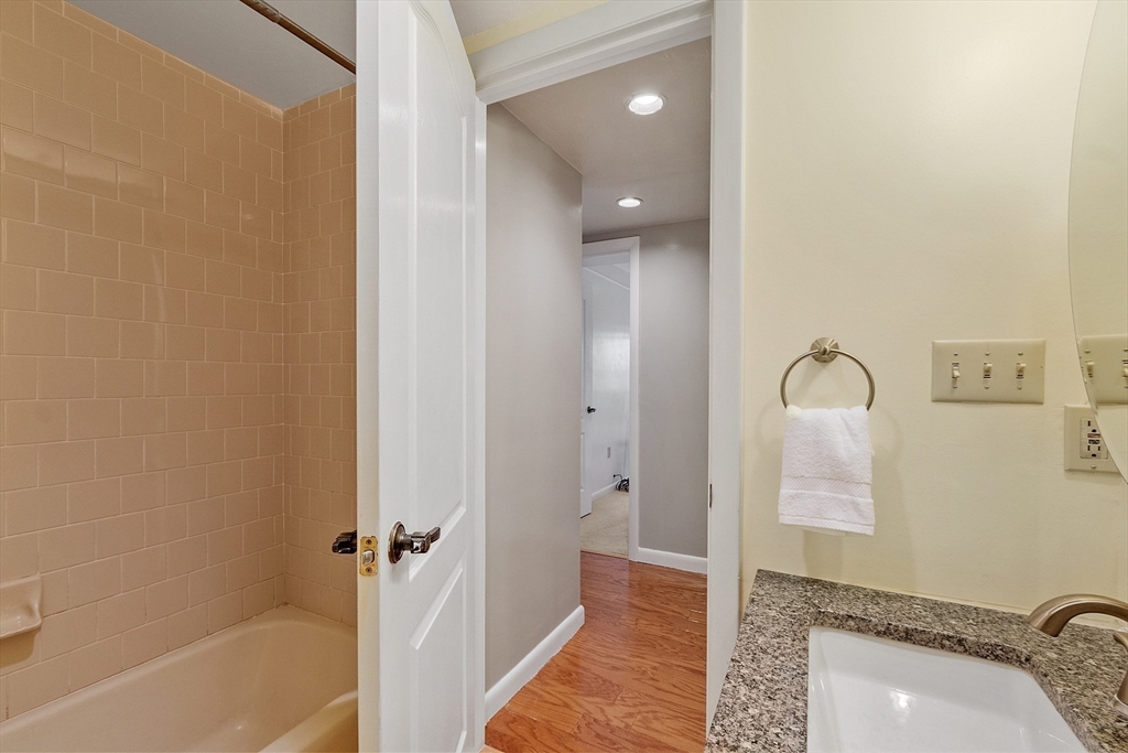 200 Falls Boulevard, Unit D108 Quincy, MA 02169 - Photo 19 of 30 a bathroom with a tub shower and sink
