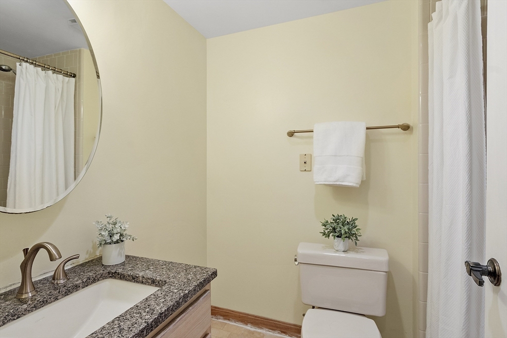 200 Falls Boulevard, Unit D108 Quincy, MA 02169 - Photo 20 of 30 a bathroom with a granite countertop sink toilet and a mirror