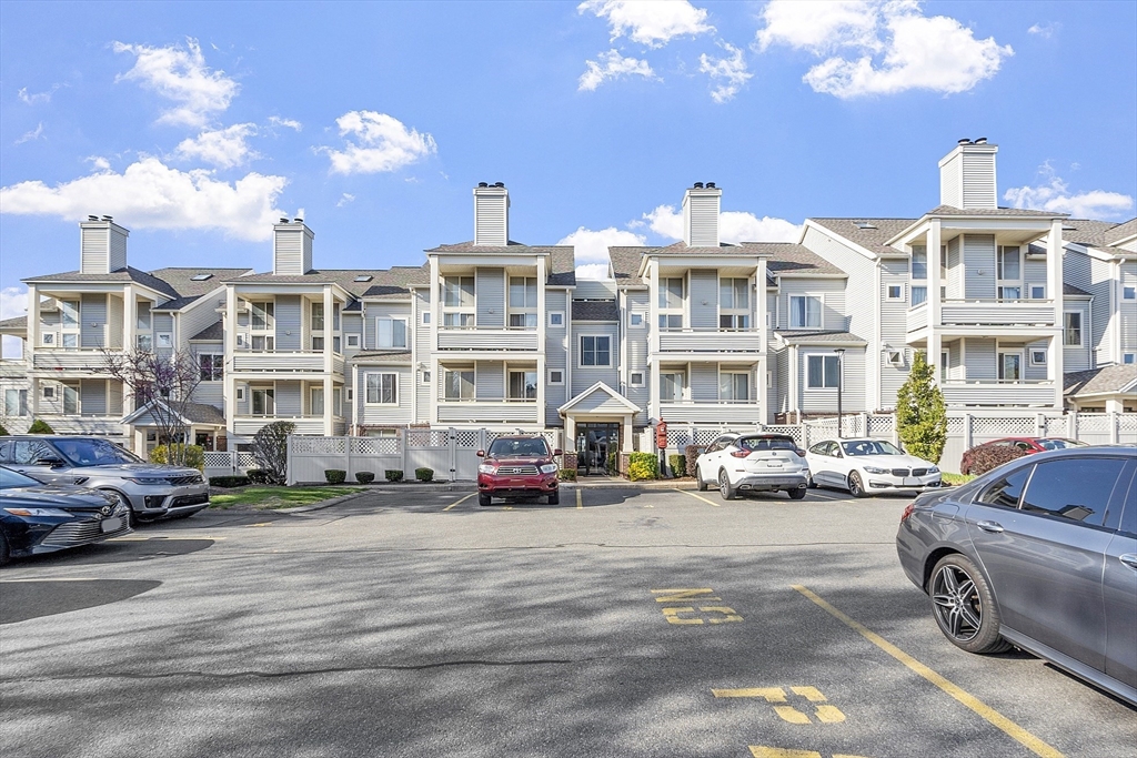 200 Falls Boulevard, Unit D108 Quincy, MA 02169 - Photo 2 of 30 a front view of a building with lot of cars and trees