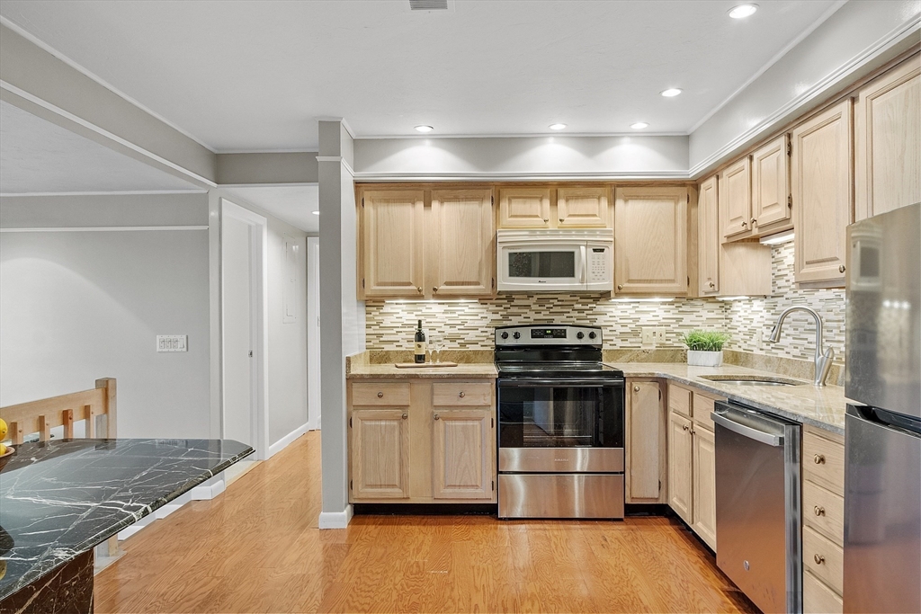 200 Falls Boulevard, Unit D108 Quincy, MA 02169 - Photo 7 of 30 a kitchen with stainless steel appliances granite countertop a stove and a sink