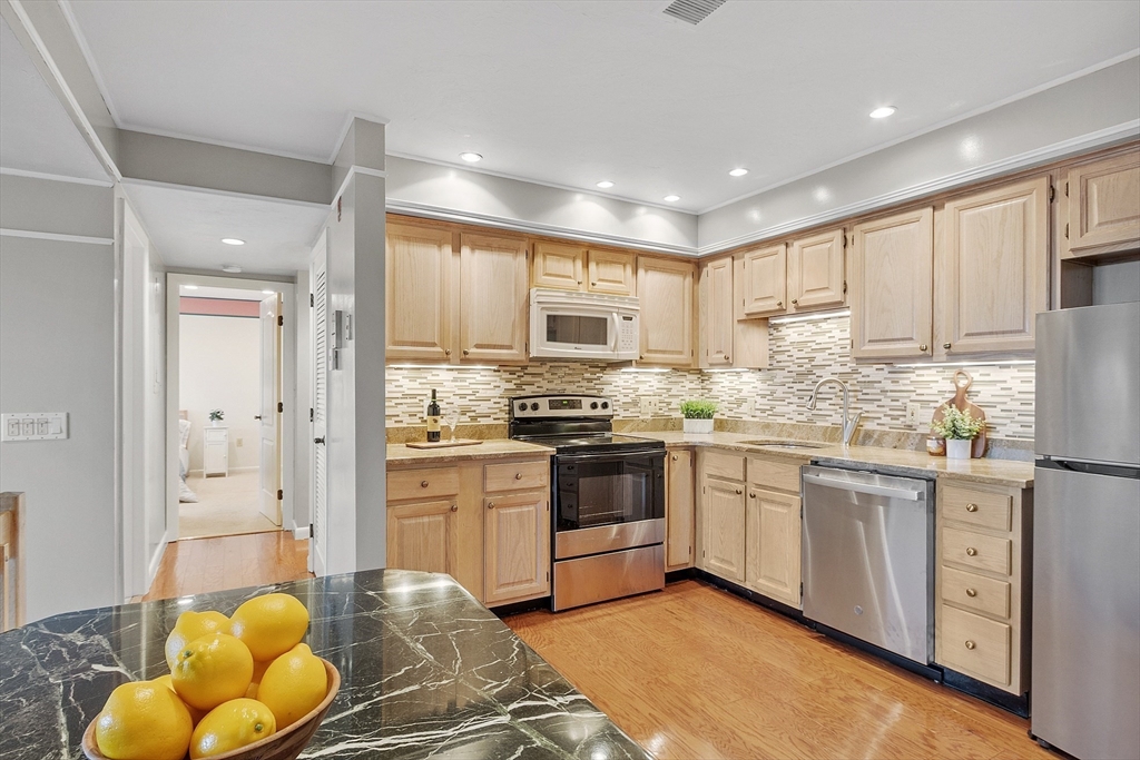 200 Falls Boulevard, Unit D108 Quincy, MA 02169 - Photo 8 of 30 a kitchen with stainless steel appliances granite countertop a stove a sink and a refrigerator