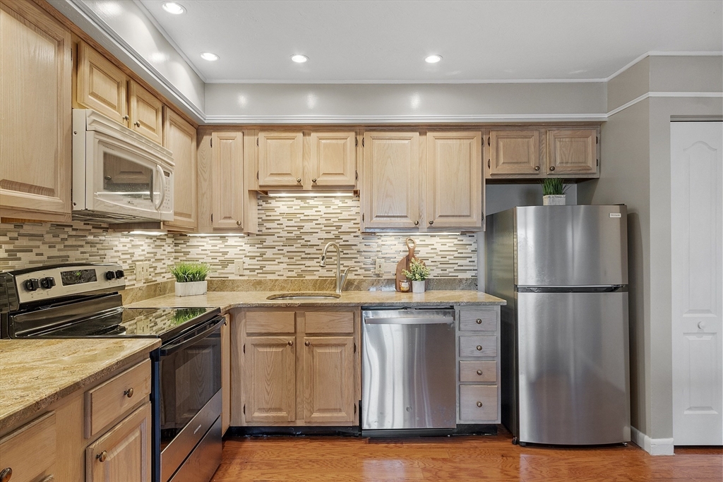 200 Falls Boulevard, Unit D108 Quincy, MA 02169 - Photo 9 of 30 a kitchen with a refrigerator sink and cabinets