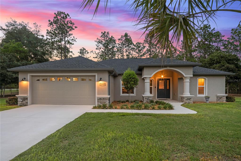 12929 Southwest 89th Street Dunnellon, FL 34432 - Photo 43 of 76 a front view of a house with a garden and a yard