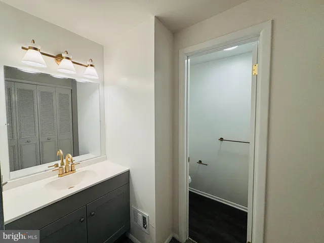 a white toilet sitting next to a bathroom sink and a shower