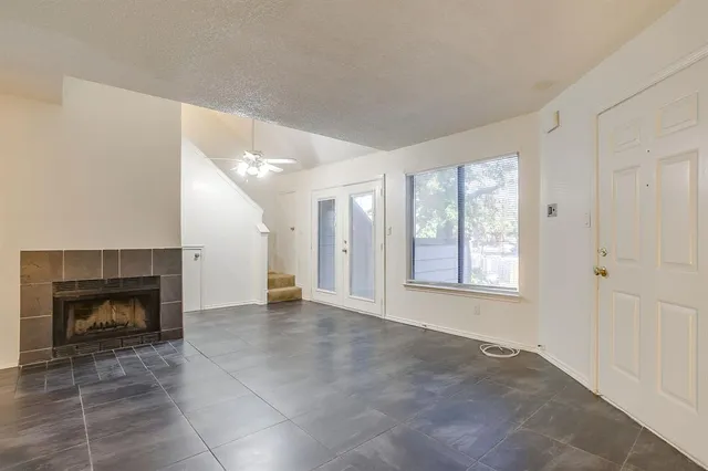 a view of an empty room with a window and fireplace
