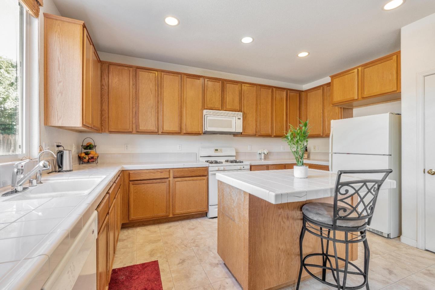 1433 Brahma Street Patterson, CA 95363 - Photo 12 of 43 a kitchen with a refrigerator a stove a sink cabinets and a dining table