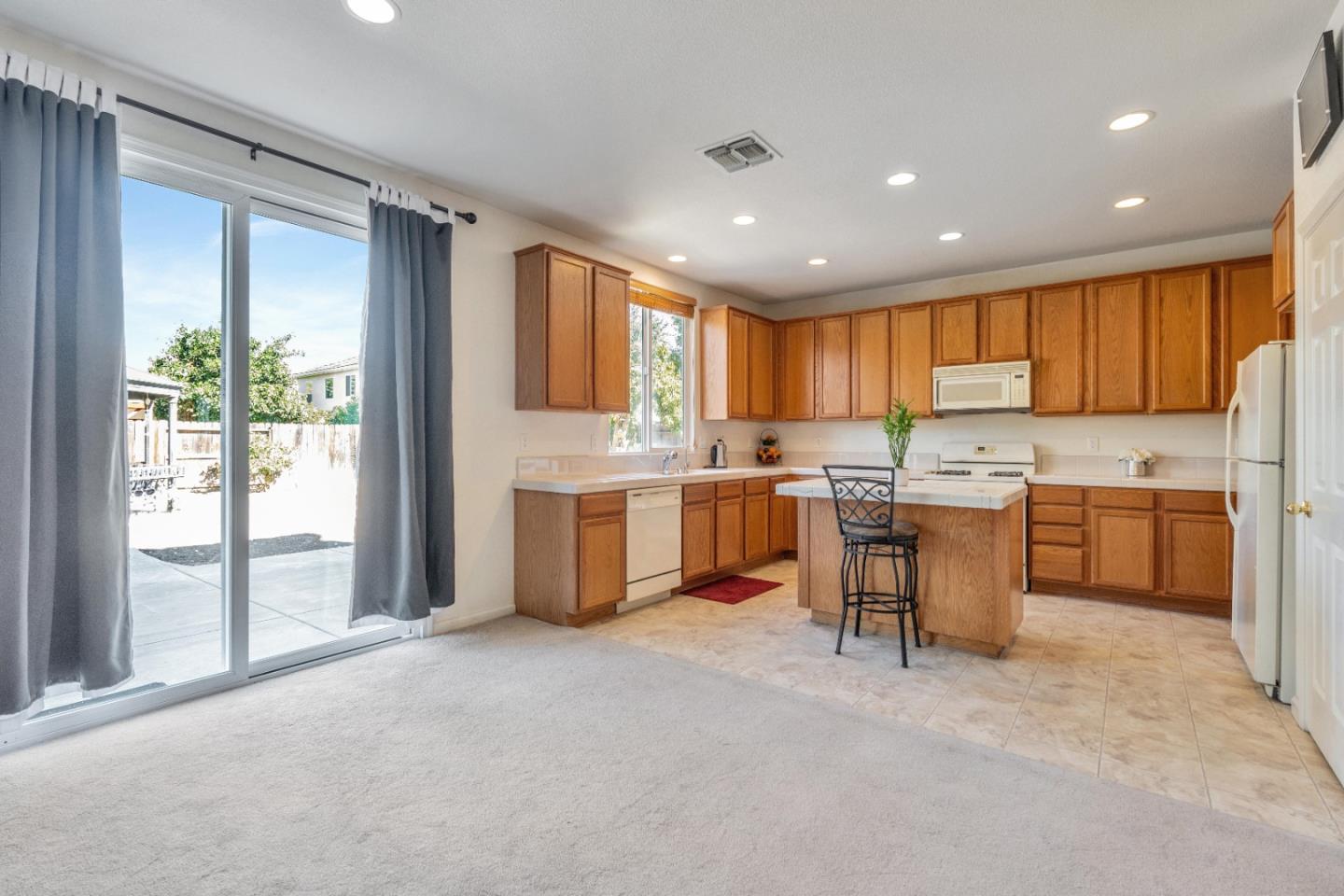 1433 Brahma Street Patterson, CA 95363 - Photo 16 of 43 a kitchen with a refrigerator a sink dishwasher with a stove and cabinets