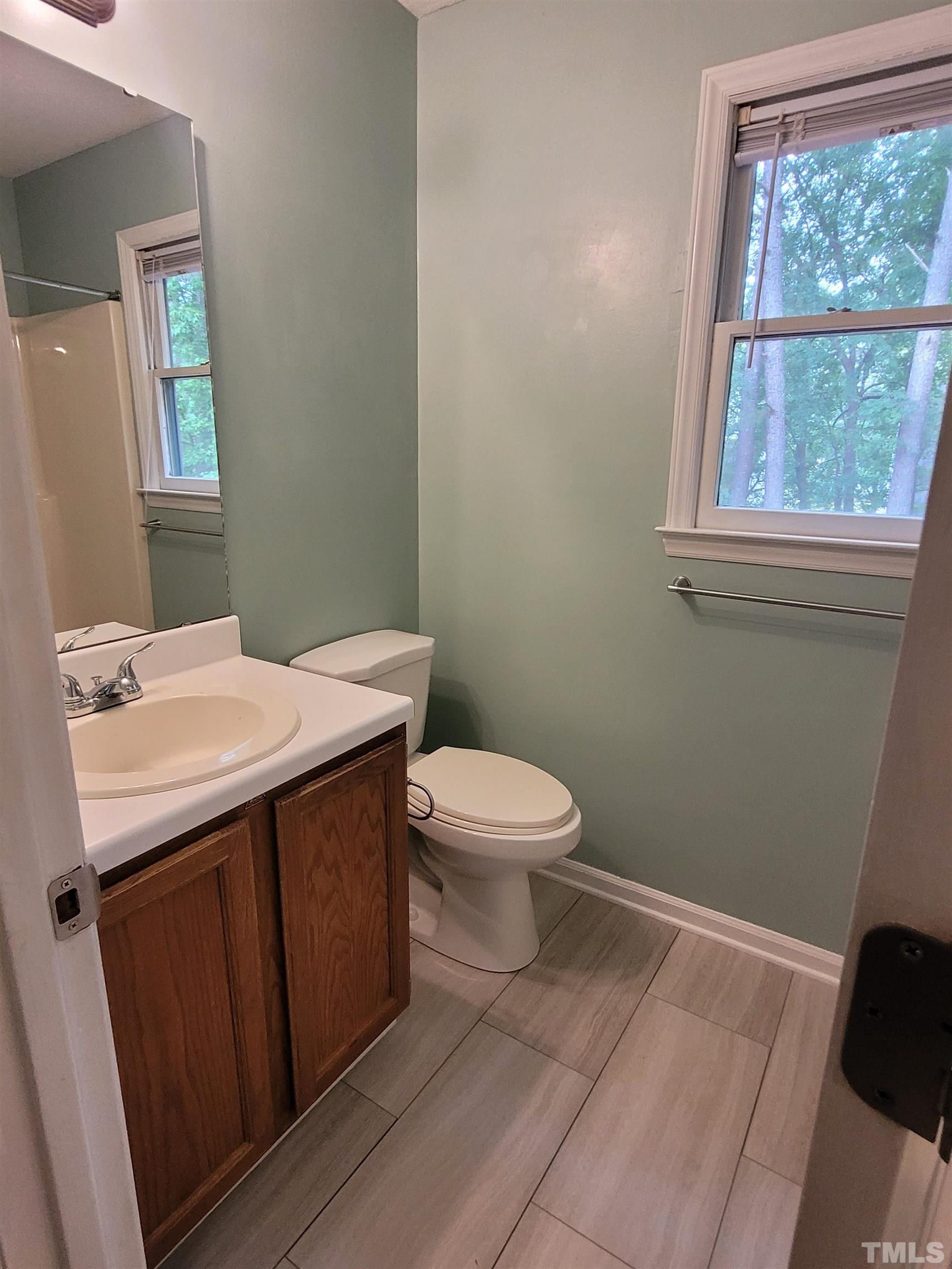 4836 Draper Road Raleigh, NC 27616 - Photo 13 of 16 a bathroom with a sink a toilet and window