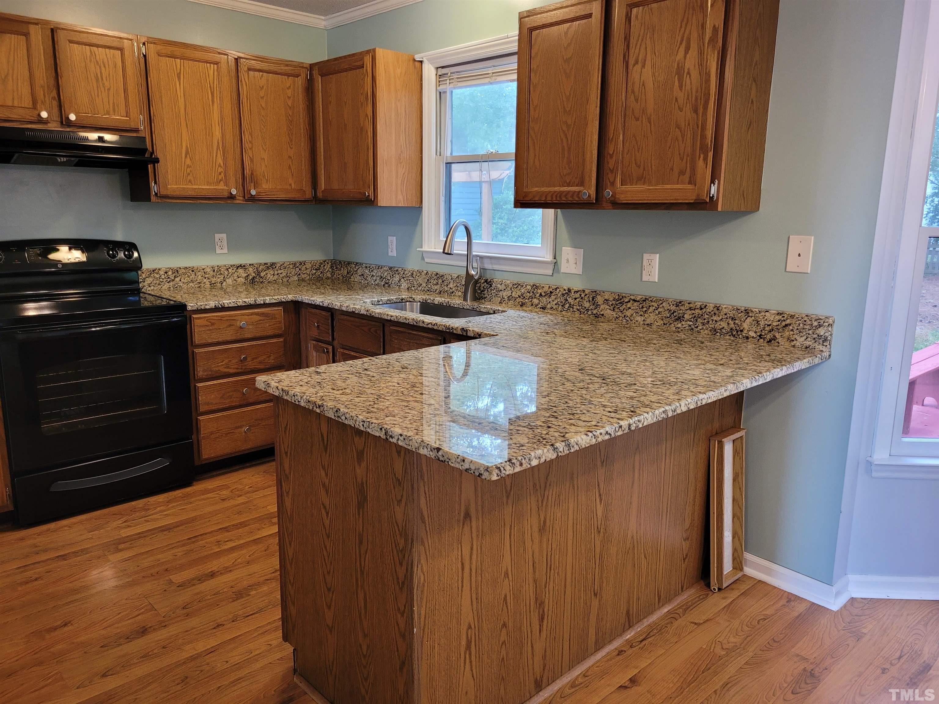 4836 Draper Road Raleigh, NC 27616 - Photo 4 of 16 a kitchen with stainless steel appliances granite countertop a sink a stove and a wooden floors