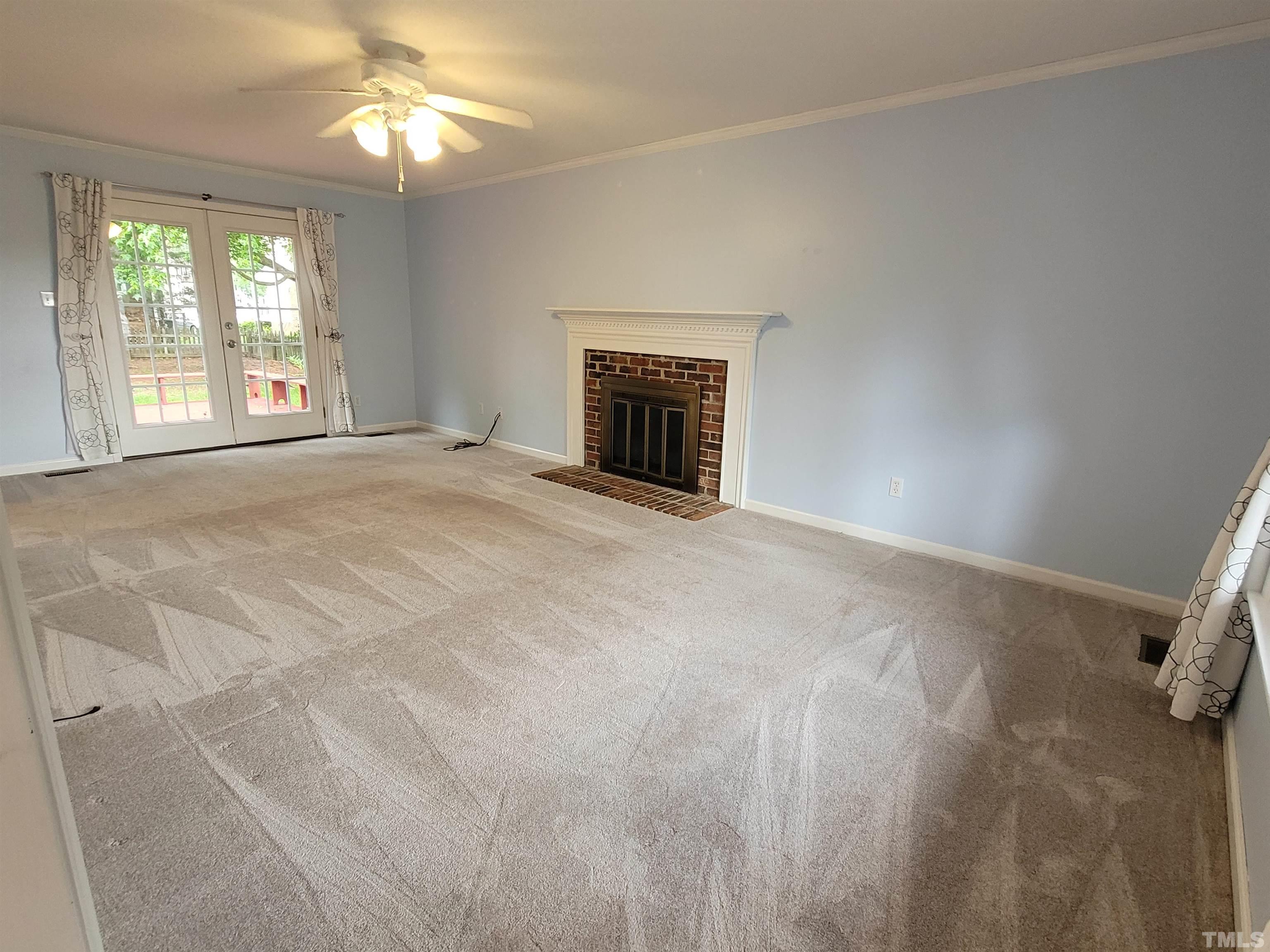 4836 Draper Road Raleigh, NC 27616 - Photo 5 of 16 en empty room with windows and fireplace