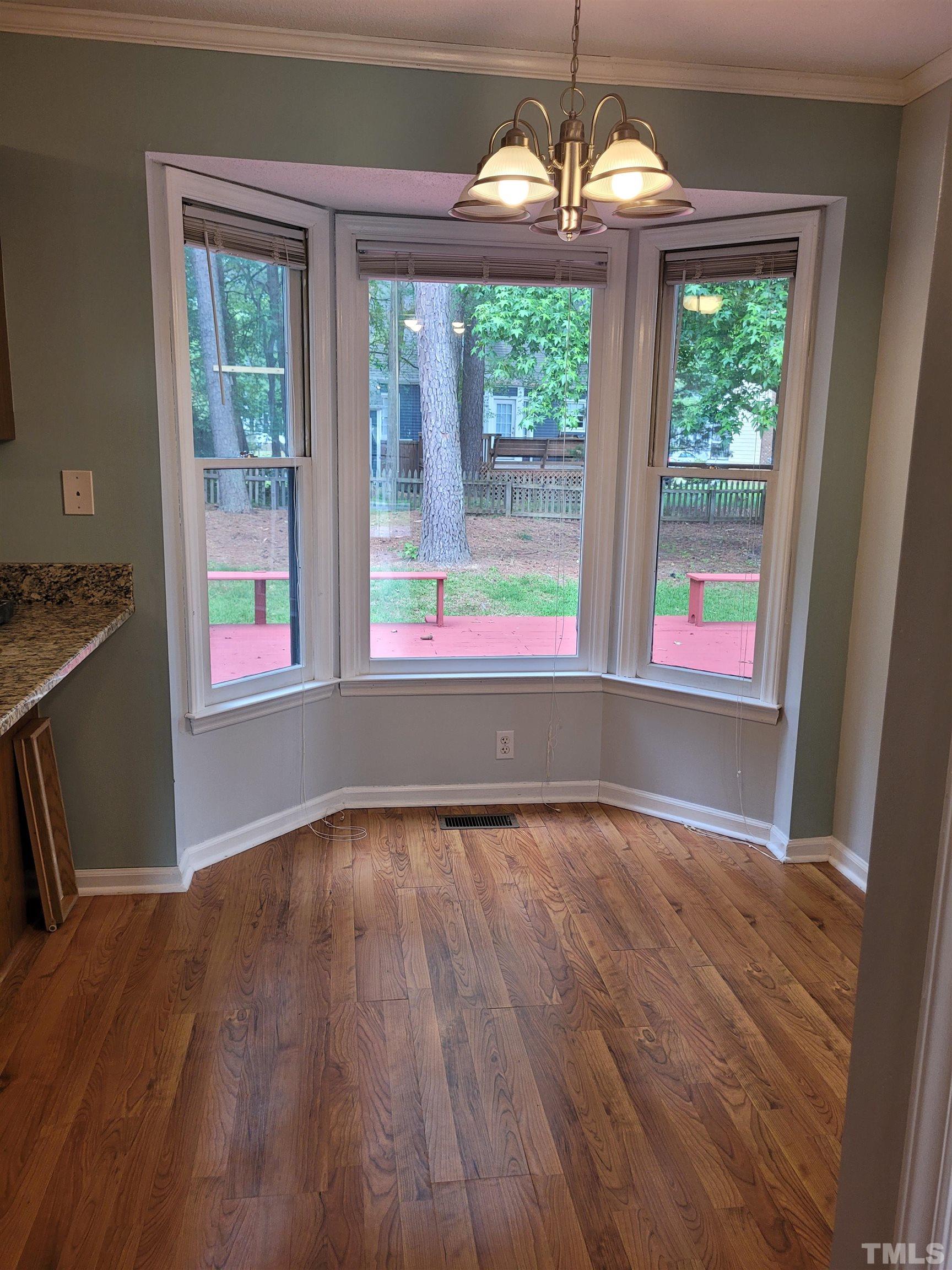 4836 Draper Road Raleigh, NC 27616 - Photo 8 of 16 a view of an empty room with wooden floor and a window