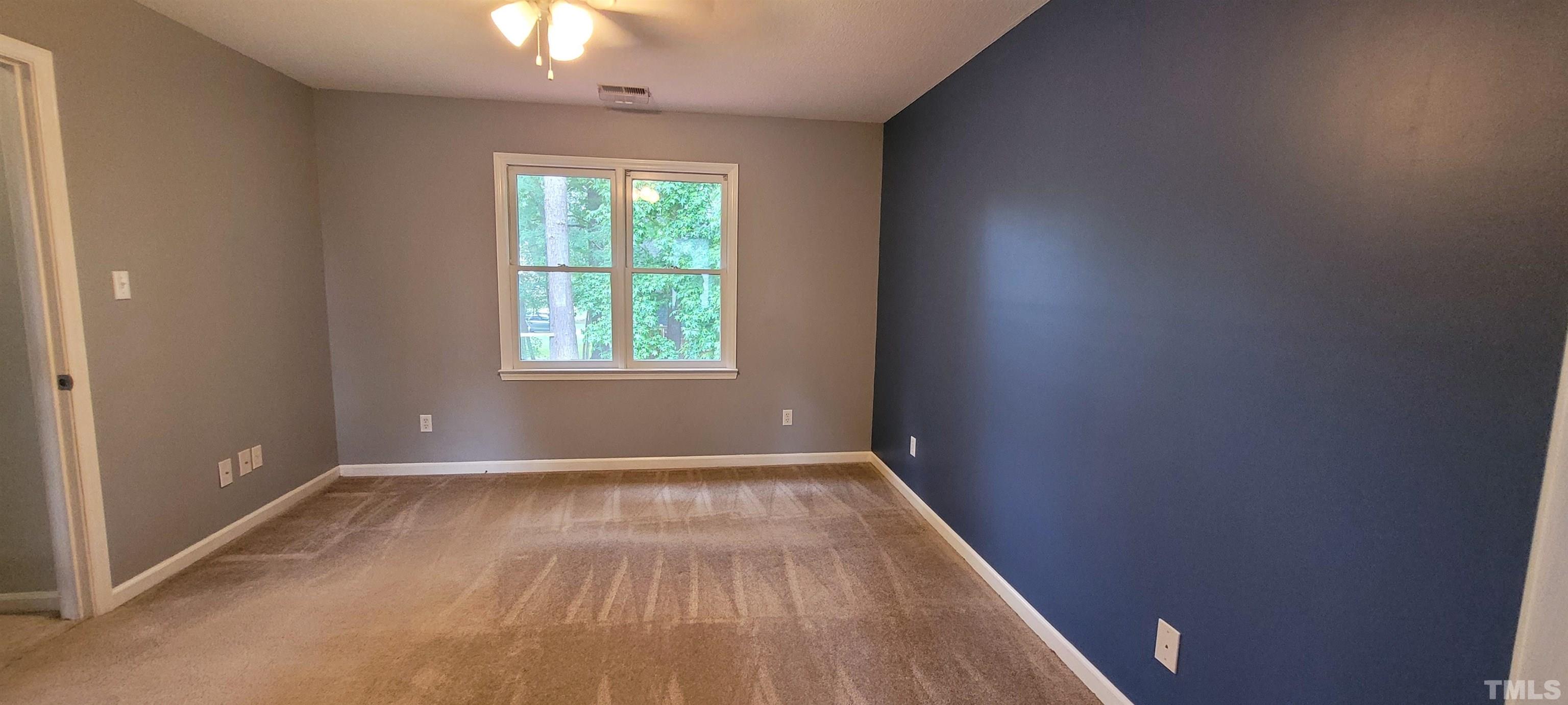4836 Draper Road Raleigh, NC 27616 - Photo 10 of 16 a view of an empty room with wooden floor and a window