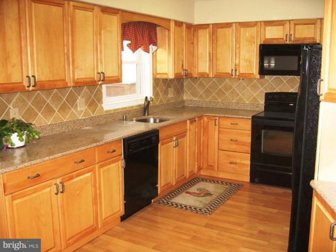 6278 Rathlin Drive Springfield, VA 22152 - Photo 11 of 25 a kitchen with granite countertop a refrigerator sink and cabinets