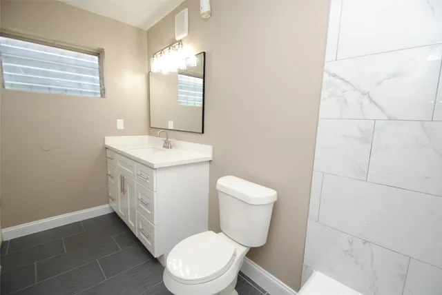 a white toilet sitting next to a bathroom sink