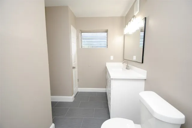 a bathroom with a toilet sink and mirror