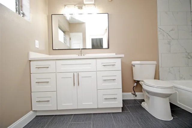 a bathroom with a toilet sink and mirror