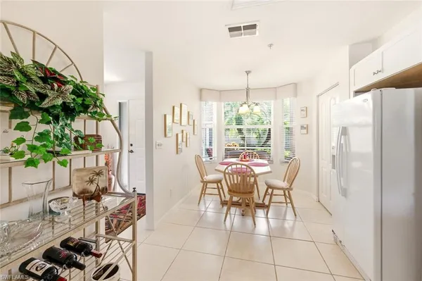 a dining room with furniture potted plants and wooden floor