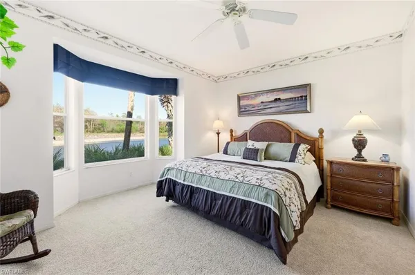 a spacious bedroom with a bed and a chandelier