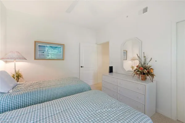 a bedroom with a bed and a potted plant