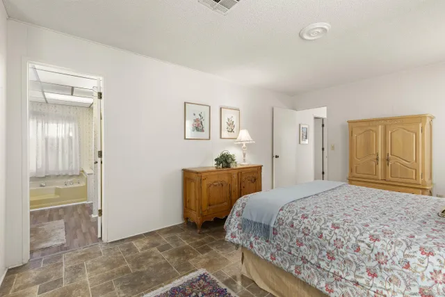 a bedroom with a bed and a painting on the wall