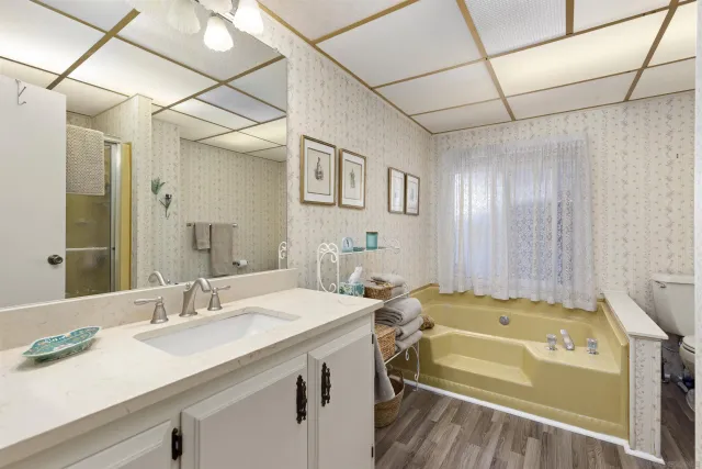 a bathroom with a tub sink and mirror