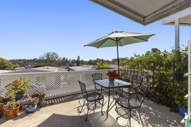 a view of a lake with a table and chairs under an umbrella